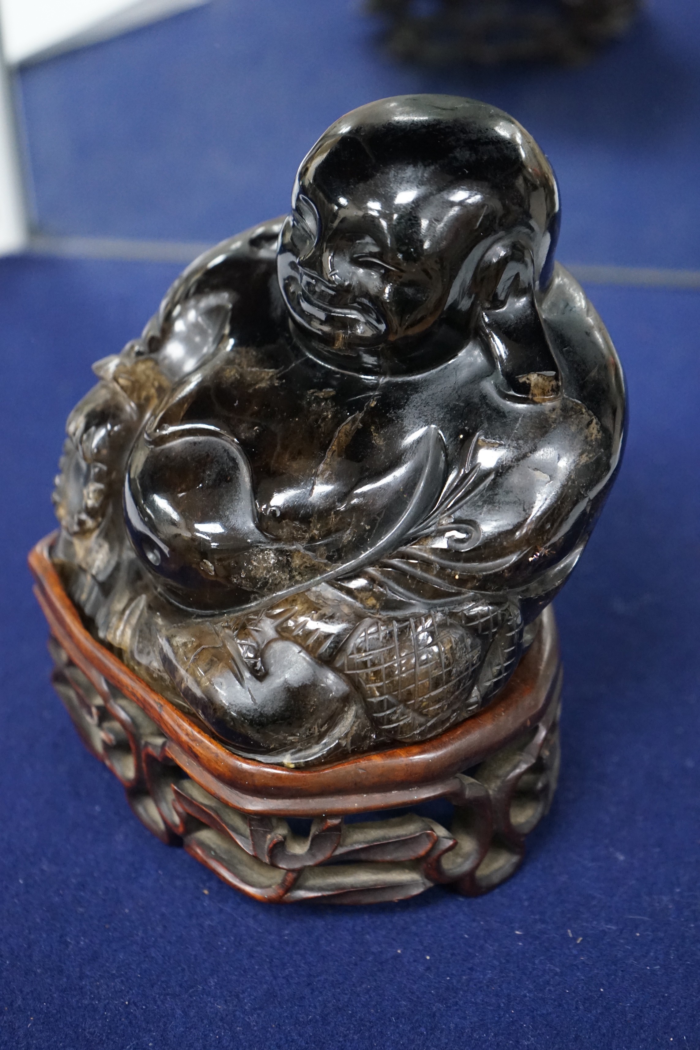 A large Chinese smoky quartz figure of Budai, 17cm tall including wood stand